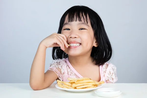 Feliz asiática china niña comiendo papas fritas —  Fotos de Stock