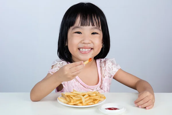 Happy Asian Chinese little girl Eating French Fries — Stock Photo, Image