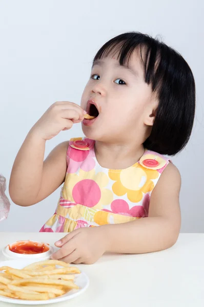 Asian Chinese little girl Eating French fries — Stock Photo, Image