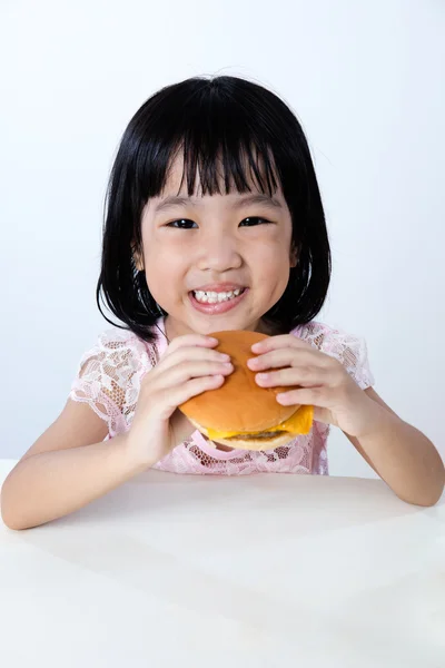 Счастливая азиатская китайская девочка ест бургер — стоковое фото