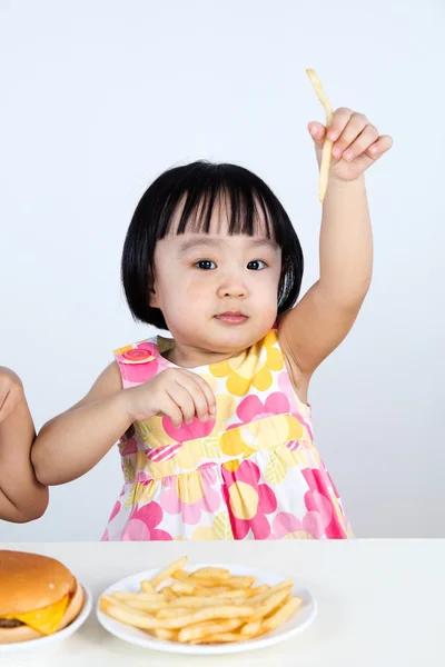 Азиатская маленькая девочка ест картошку фри — стоковое фото
