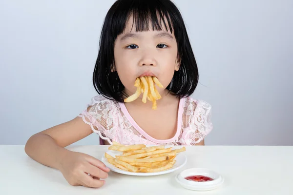 Asiática china niña negándose a comer papas fritas — Foto de Stock