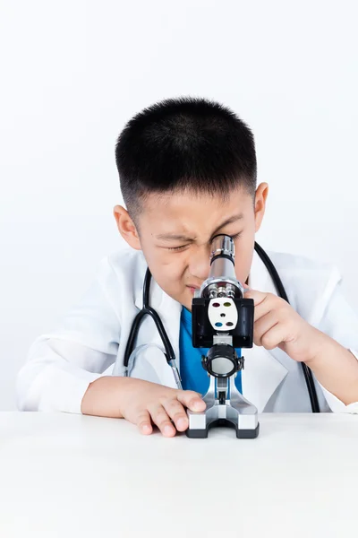 Azjatycki chiński chłopiec pracy z mikroskopem — Zdjęcie stockowe