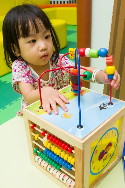 Chinese girl solving puzzle — Stock Photo, Image