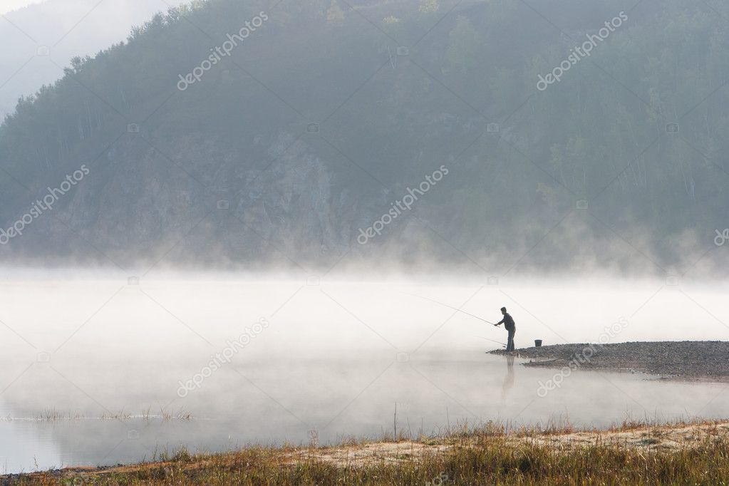 Man fishing at river shore 