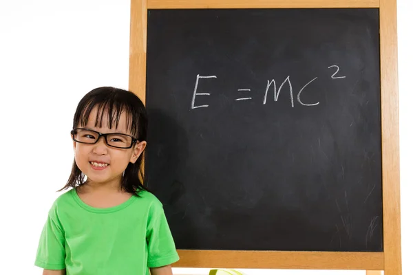 Asian Chinese little girl againts blackboard with formulas — Stock Photo, Image