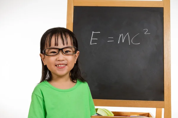 Asian Chinese little girl againts blackboard with formulas — Stock Photo, Image