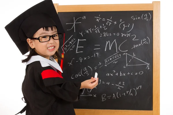 Asian Chinese little girl in graduation gown againts blackboard — Stock Photo, Image