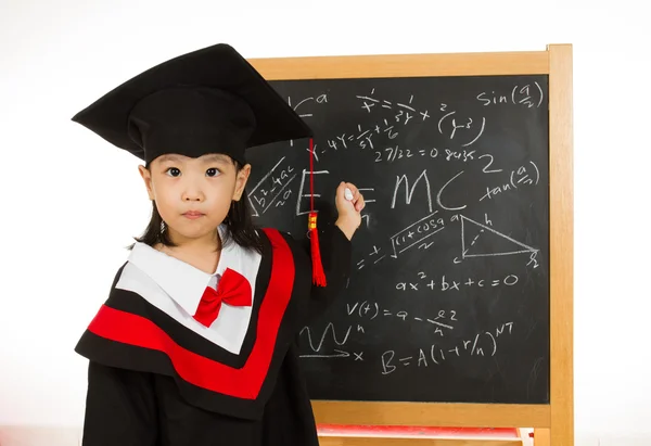 Asian Chinese little girl in graduation gown againts blackboard — Stock Photo, Image