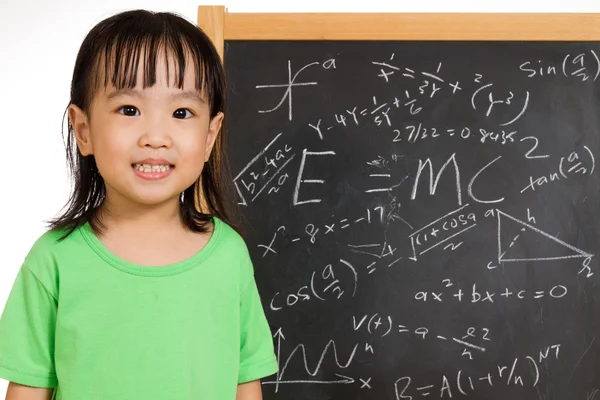 Asian Chinese little girl againts blackboard with formulas — Stock Photo, Image