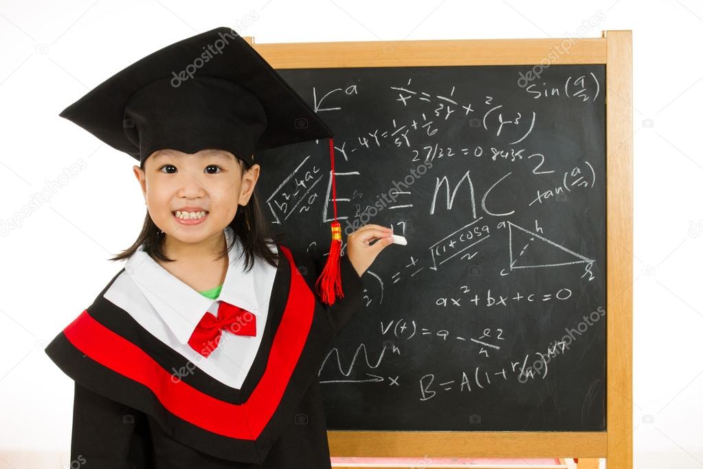 Asian Chinese little girl in graduation gown againts blackboard