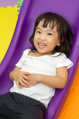 Asyalı Çinli küçük kız slayt üzerinde oynama