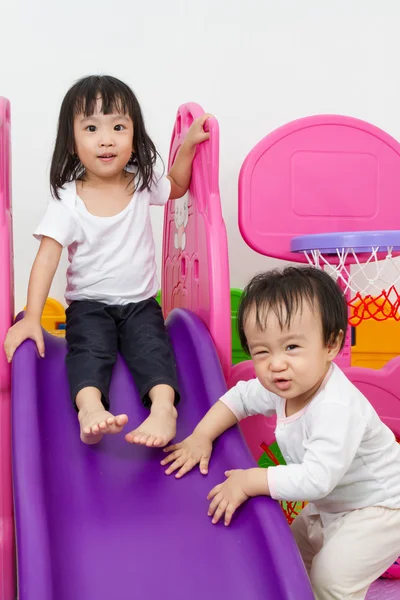 Asian Chinese little sister and brother playing on the slide — Stock Photo, Image