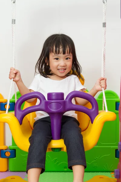 Asiatiska kinesiska liten flicka spelar på swing — Stockfoto