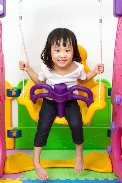 Asiatiska kinesiska liten flicka spelar på swing — Stockfoto