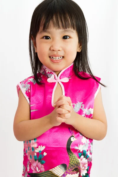 Chinesisches kleines Mädchen trägt Cheongsam mit Grußgeste — Stockfoto