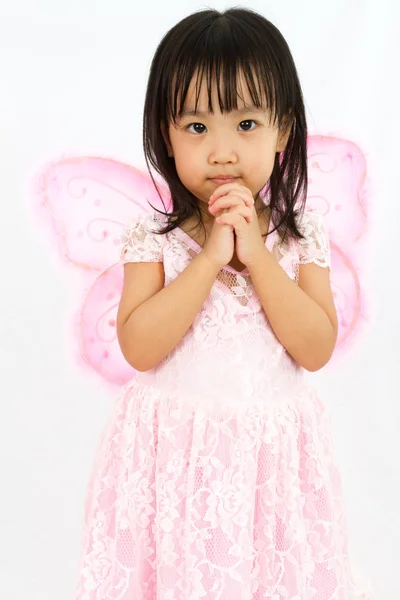 Niña china usando mariposa custome con gesto de oración —  Fotos de Stock