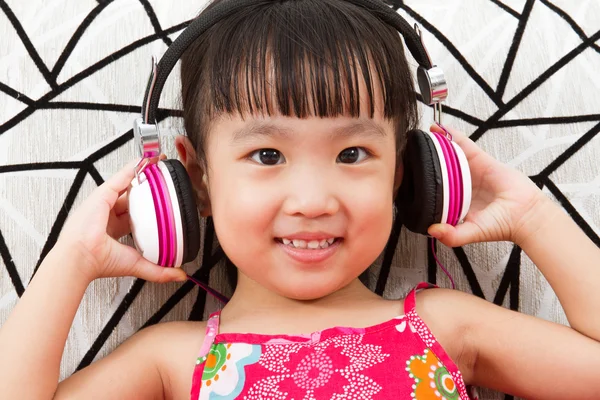 Chino niña en auriculares celebración de teléfono móvil —  Fotos de Stock