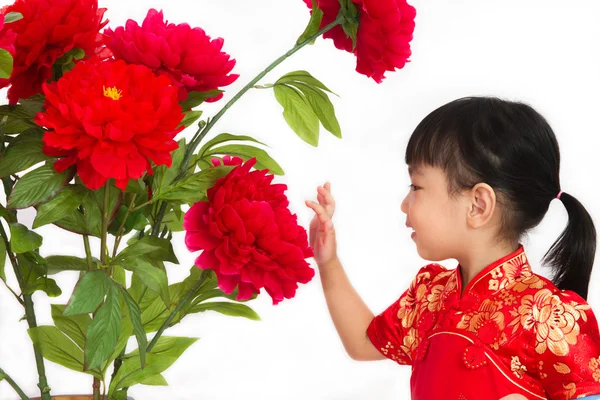 Niña china vestida de rojo posando con flores — Foto de Stock