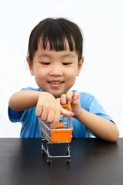 Chinesisches kleines Mädchen schiebt einen Spielzeugwarenkorb — Stockfoto