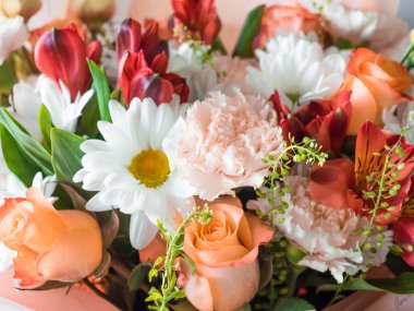 Çiçekler yakın plan. Bir buket papatya, karanfil, zambak, pastel gölgeli güller. Toplanan buket