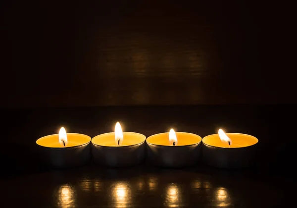 在木制楼梯上点燃蜡烛的特写 蜡烛带来的舒适和温暖 一连有四支蜡烛 侧视图 黑暗背景 — 图库照片