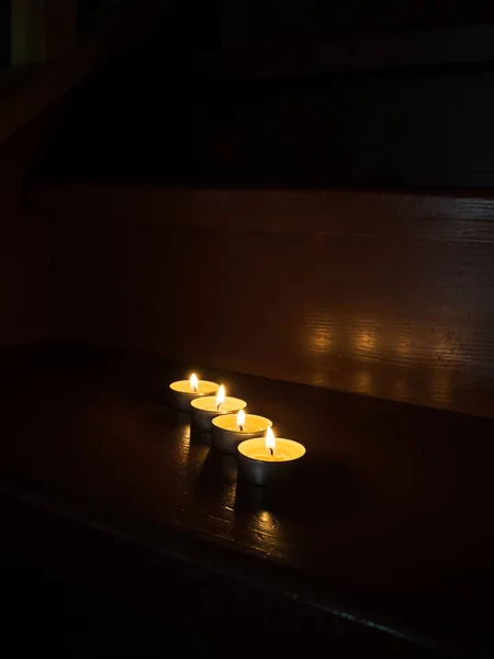 在木制楼梯上点燃蜡烛的特写 蜡烛带来的舒适和温暖 一连有四支蜡烛 侧视图 黑暗背景 — 图库照片