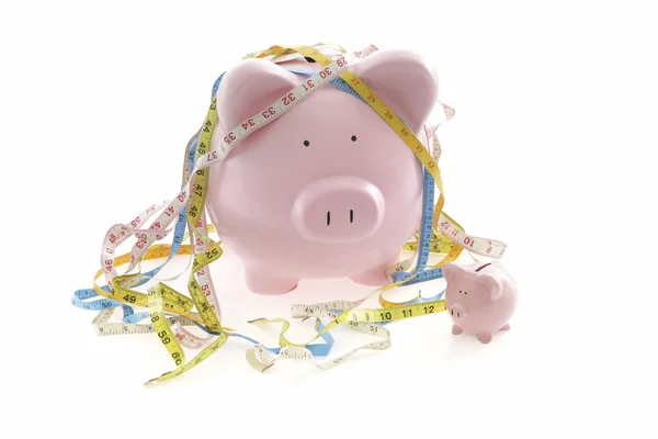 Piggy Banks and measuring tape — Stockfoto