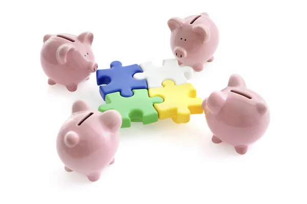 Piggy Banks and puzzle parts — стокове фото