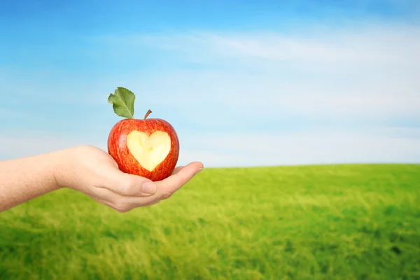 Apfel mit Herzbiss in der Hand — Stockfoto