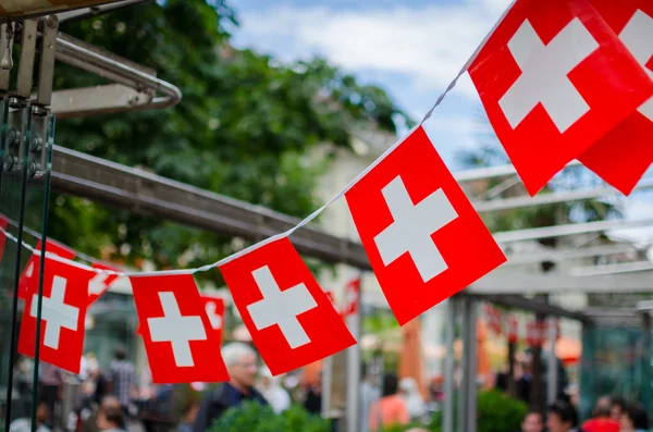 swiss flags hang outdoor on Swiss National Day in Bern