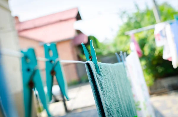 Alfileres azules en la cuerda y una toalla colgante — Foto de Stock