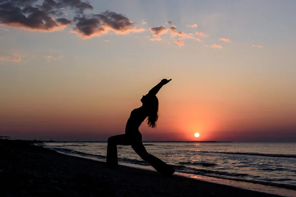 Chica en la playa al amanecer en yoga assana —  Fotos de Stock