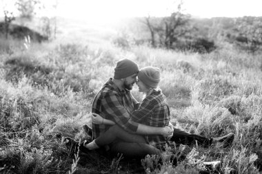 Neşeli adam ve kız parlak örgü şapkalar ve ekose gömleklerle yürüyüşe çıktılar.