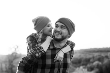 Neşeli adam ve kız parlak örgü şapkalar ve ekose gömleklerle yürüyüşe çıktılar.