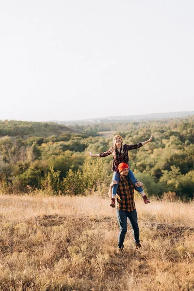 Neşeli adam ve kız parlak örgü şapkalar ve ekose gömleklerle yürüyüşe çıktılar.