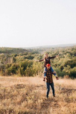 Neşeli adam ve kız parlak örgü şapkalar ve ekose gömleklerle yürüyüşe çıktılar.