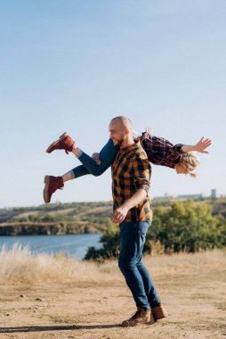 Kafesteki gömlekli adam ve kız granit kayalıklarda yürüyüş ayakkabıları.
