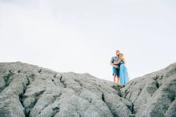 ライトブルーのドレスを着たブロンドの女の子とライトシャツを着た男と花崗岩の採石場での短いシャツ — ストック写真