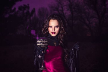 Gece ormanda tek başına bir iksir hazırlar ve evliliğin mucizeleri, mumlar ve dumanlarla çevrili.