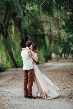 Bir adam ve bir kız, orman ve söğütlerle kaplı vahşi bir nehrin kıyısında yürüyorlar.