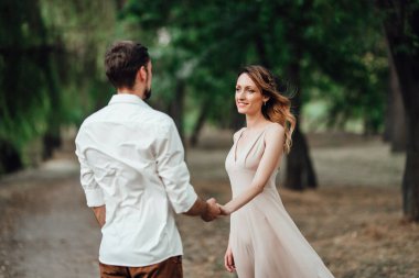 Bir adam ve bir kız, orman ve söğütlerle kaplı vahşi bir nehrin kıyısında yürüyorlar.