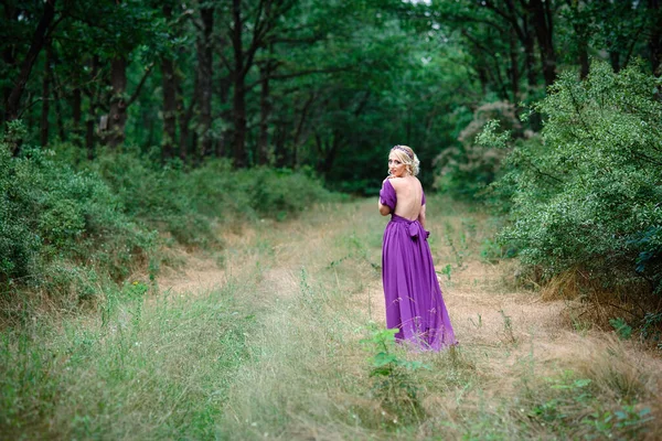 Девушка Блондинка Сиреневом Платье Букетом Зеленым Лесом — стоковое фото