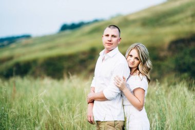 Dünya 'nın yeşil bir kanyonunun arka planında hafif elbiseli bir kızla bir adam.