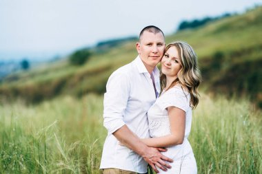 Dünya 'nın yeşil bir kanyonunun arka planında hafif elbiseli bir kızla bir adam.