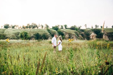 Dünya 'nın yeşil bir kanyonunun arka planında hafif elbiseli bir kızla bir adam.