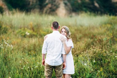 Dünya 'nın yeşil bir kanyonunun arka planında hafif elbiseli bir kızla bir adam.