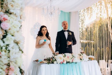 Yeni evlilerin portresi düğün şöleninde başkanlık makamında.