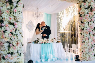 Yeni evlilerin portresi düğün şöleninde başkanlık makamında.