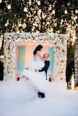 Gelin ve damadın ilk dansı açık hava restoranında ağır beyaz dumanla